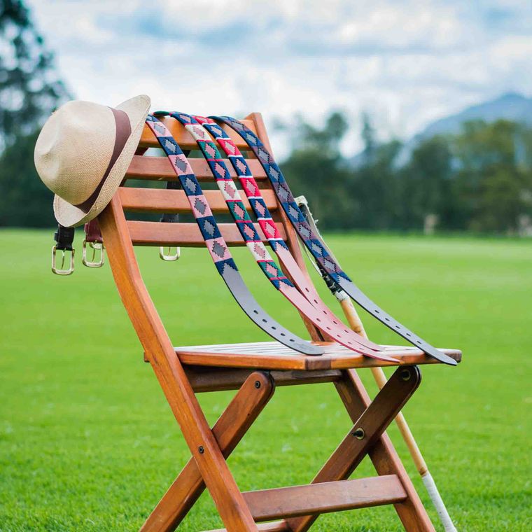 Woven belts hanging on a wooden chair on the polo field