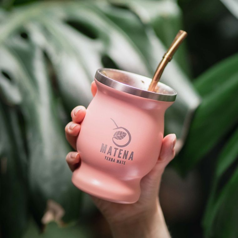 A pink Matena mate cup held against leaves