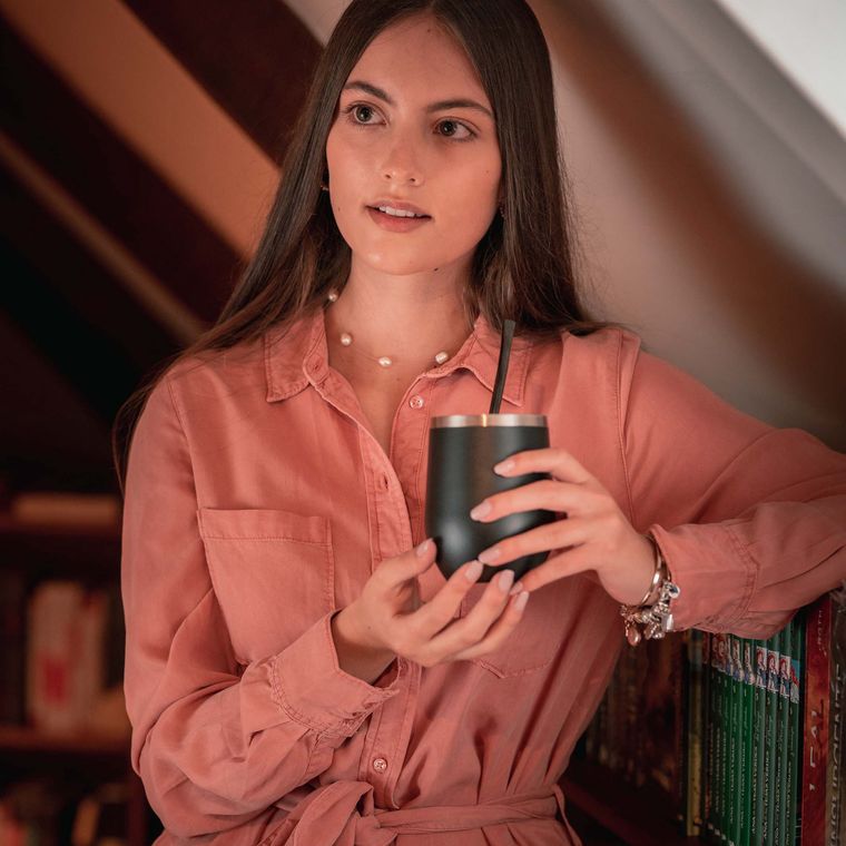 A woman holding a thermos cup